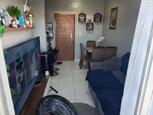 a living room with a blue couch and a television at ApartamentoA306 in Ananindeua