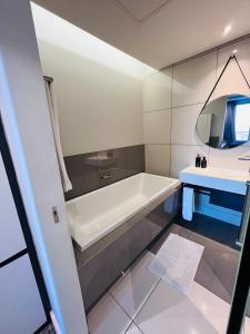 a bathroom with a bath tub and a sink at Sandton Pool View with Balcony in Johannesburg