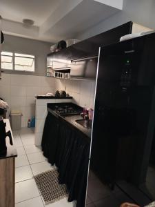 a kitchen with a black refrigerator and a sink at ApartamentoA306 in Ananindeua +2 photos