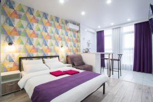 een slaapkamer met een bed en een kleurrijke muur bij Doba In Ua Luhovska255 Apartments in Dnipro