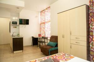 een kamer met een bed en een stoel en een keuken bij Doba In Ua Luhovska255 Apartments in Dnipro