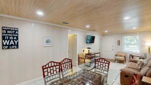 a living room with a glass table and chairs at BEACHY SISTERS B Duplex in Jekyll Island