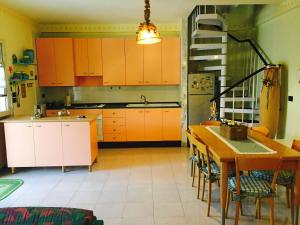 a kitchen with orange cabinets and a wooden table at Villarichi in Manfredonia