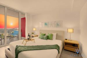 a bedroom with a large bed and a balcony at Condo Retreat with Stunning Views and Amazing Pools in Hallandale Beach