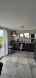 a kitchen with black cabinets and a large window at Alpaca World Friesland in Workum
