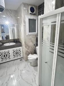 a bathroom with a shower and a toilet and a sink at Luxury Apartment in Hurghada +11 photos