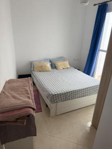 a small bedroom with a bed and a window at Spacious 80m 2 chambre in El Jadida