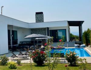 a house with a swimming pool and an umbrella at DREAM VIEW Saguramo in Saguramo