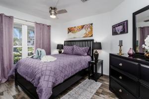a bedroom with a purple bed and a window at Dream Tropical Oasis 10 mins Walking to the Beach in Marco Island +50 photos