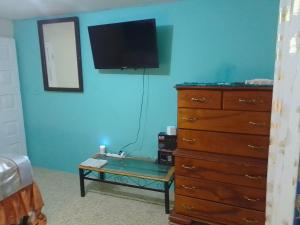 a bedroom with a dresser and a tv on the wall at Bayview Luxury Retreat  +24 photos