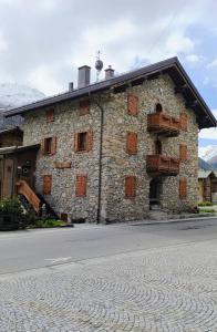 een groot stenen gebouw met houten balkons bij PiZABELA MANSARDE in Livigno