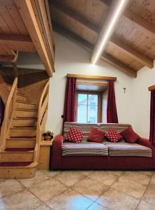 een woonkamer met een bank en een trap bij PiZABELA MANSARDE in Livigno