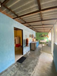 a room with a blue wall and a kitchen at Casa de Praia Descanso das Trilhas in Angra dos Reis +16 photos