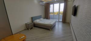a small bedroom with a bed and a window at Astara Kaspi Apart 2-5 in Astara