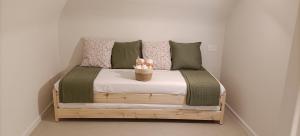 a bed with green and pink pillows and a basket on it at b&b Castrum in Terlizzi