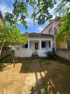 a white house with trees in front of it at Casa de Praia Descanso das Trilhas in Angra dos Reis