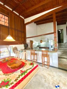 une cuisine et une salle à manger avec une table et des chaises dans l'établissement Vila Costa Sul Chalés e Estúdios, à Ilhabela