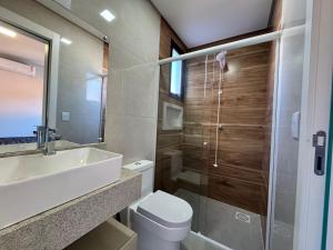 a bathroom with a toilet and a sink and a shower at Polaris Residence Apto 2 Suítes para até 8 pessoas na Praia de Palmas in Governador Celso Ramos +7 photos