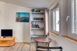 a room with a desk and a computer and a window at Appartement Sous Les Toits in Pézenas