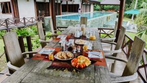 a wooden table with a plate of food on it at Luxurious Private Holiday Villa at Tip of Borneo in Kudat