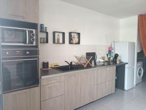 a kitchen with a sink and a microwave at Chez Gilles in Pointe-à-Pitre