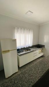 a white kitchen with a sink and a refrigerator at Kitnet tipo Apartamento Mobiliado em Itu para até 6 pessoas Temporada in Itu