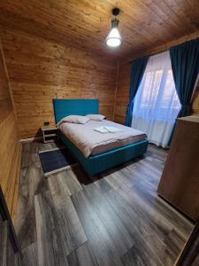 a bedroom with a bed in a wooden room at Cabana Deliuta in Cavnic