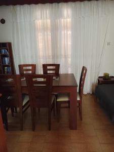 ein Esszimmer mit einem Holztisch und Stühlen in der Unterkunft DORA'S HOUSE Douneika in Amaliada