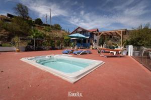 a large swimming pool on a patio with a house at Chalet, breathtaking sea view with large jacuzzi in Almuñécar