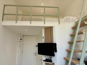 a room with two bunk beds and a flat screen tv at Studio Dore Fshh in Nice