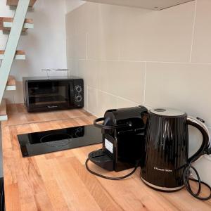 a kitchen with a microwave and a toaster and a coffee maker at Studio Dore Fshh in Nice