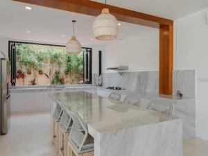ケロボカンにあるThe Ultimate Canggu Getaway!のキッチン(大理石の大きなカウンター、椅子付)