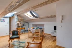 una sala de estar con una mesa y sillas en Appartement Le Colombier, en Béziers
