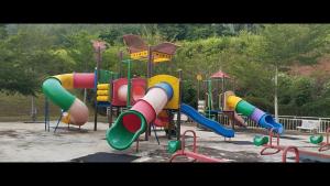 a park with a playground with a colorful slide at Triple H Homestay in Jitra
