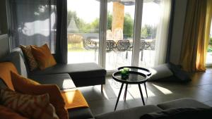 a living room with couches and a table and a balcony at Lovely Sunset -Villa Zoe in Nea Moudania