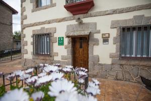 a building with white flowers in front of it at Casa Rural Lagun Etxea in Pobes