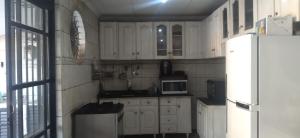 a kitchen with white cabinets and a white refrigerator at Cop 30 in Belém
