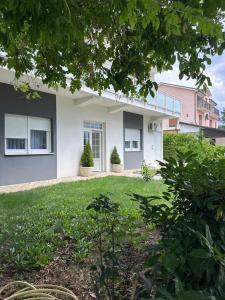 a house with two potted plants in a yard at Apartmani Novak in Mostar