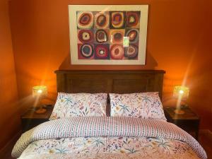 a bedroom with a bed with two lamps and a painting at Okovango Cabin in Holton