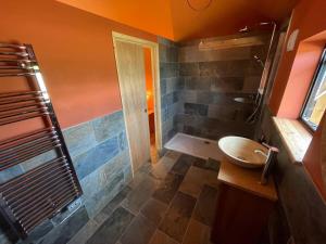 a bathroom with a tub and a sink and a shower at Okovango Cabin in Holton +4 photos