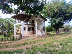 a small white house with a thatched roof at Sea Soul Sanctuary in Ukunda