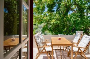 a wooden table and chairs on a patio with a window at Astradeni Studios in Kámpos
