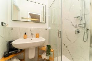 Un baño blanco con lavabo y ducha. en Appartamento Green House, en Turín 17 fotos más
