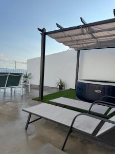 a patio with a table and chairs and an umbrella at Raízes AL in Povoação