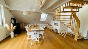 a dining room with a table and chairs and a staircase at SOLUNA STAY I Seesicht I Luzern I Familienfreundlich I Self-check-in I Sunset I Ski I Free Parking in Küssnacht