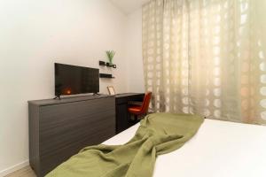 Un dormitorio con una cama y un escritorio con televisión. en Appartamento Green House, en Turín