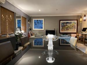 a living room with a table and a dining room at The Little Mongrel Deluxe Space Bryanston in Johannesburg