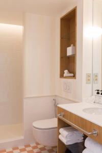 a bathroom with a toilet and a sink at Hôtel Maison Borrèze in Souillac