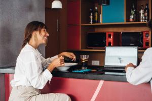a woman sitting at a counter with a plate of food at Stay Hotel Faro Centro in Faro