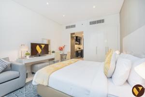 a bedroom with a king sized bed and a couch at Vogue Vacation Homes, Business Bay Damac Cour Jardin close to Downtown, Burj Khalifa and Dubai Mall, Studio Apartment with City View, Access to all Amenities in Dubai